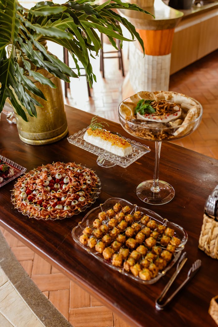Mastering the First Impression: Your intriguing post title goes here A lavish buffet display featuring appetizers, desserts, and gourmet dishes on a wooden table indoors.