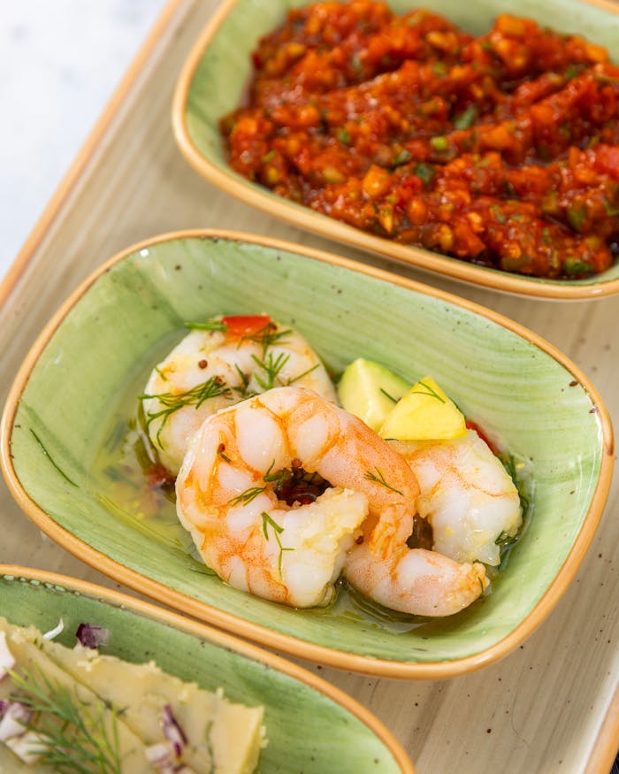 Delicious shrimp with herbs, red sauce, and cheese appetizers served elegantly.