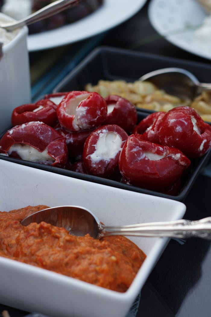 Crafting Captivating Headlines: Your awesome post title goes here Close-up of stuffed peppers with creamy filling and red pepper dip in bowls. Ideal for food photography.