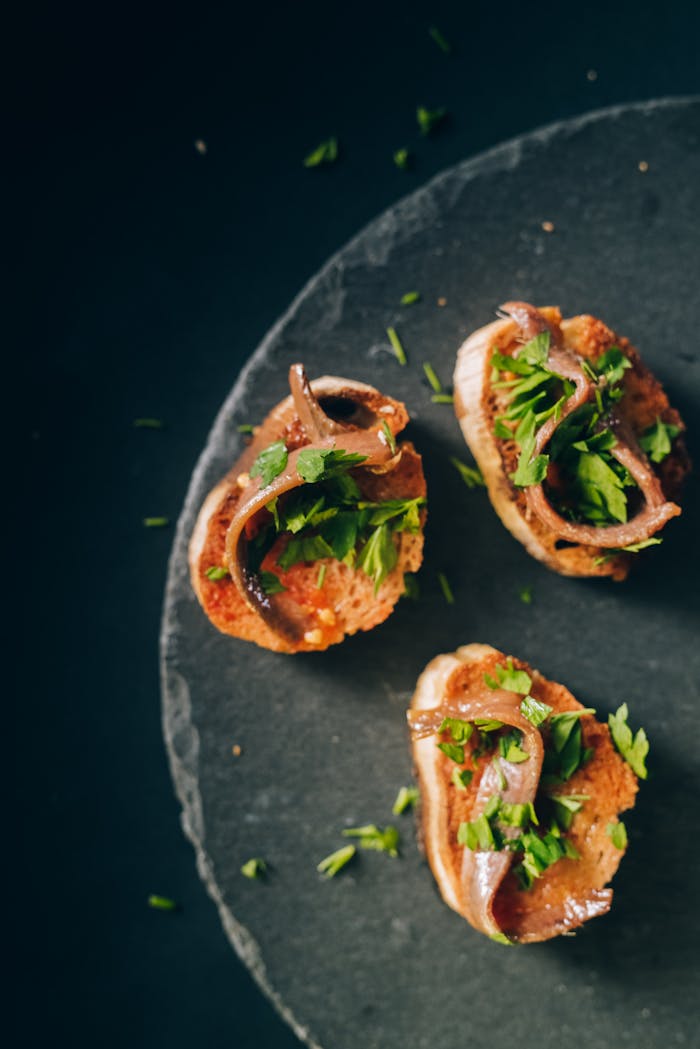 Delicious anchovy toasts garnished with fresh cilantro, photographed as an overhead shot.